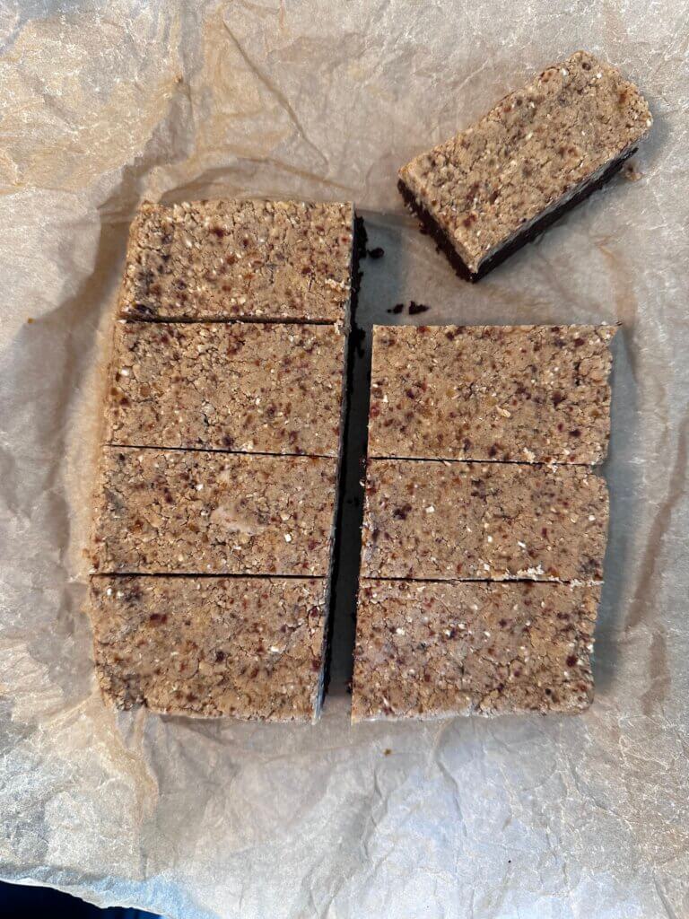 Zubereitung der Proteinriegel – Brownie-Schicht und Cookie-Dough-Schicht in Form geschichtet